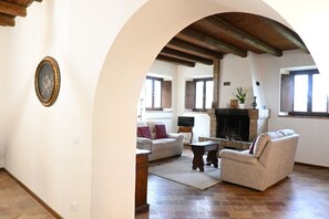 Un salon avec une cheminée, un canapé, une table basse et un téléviseur.