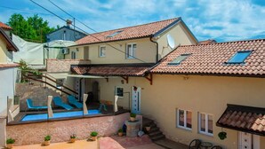 A two-story house with a swimming pool, outdoor seating, and a small garden. - Lovely apartment in Veli Brgud with WiFi (Veli Brgud)