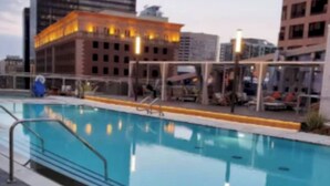 A swimming pool with a tiled deck, surrounded by buildings. - City Skyline Views 3Bed Apt with Rooftop Pool, Spa,& Rooftop deck (Los Angeles)