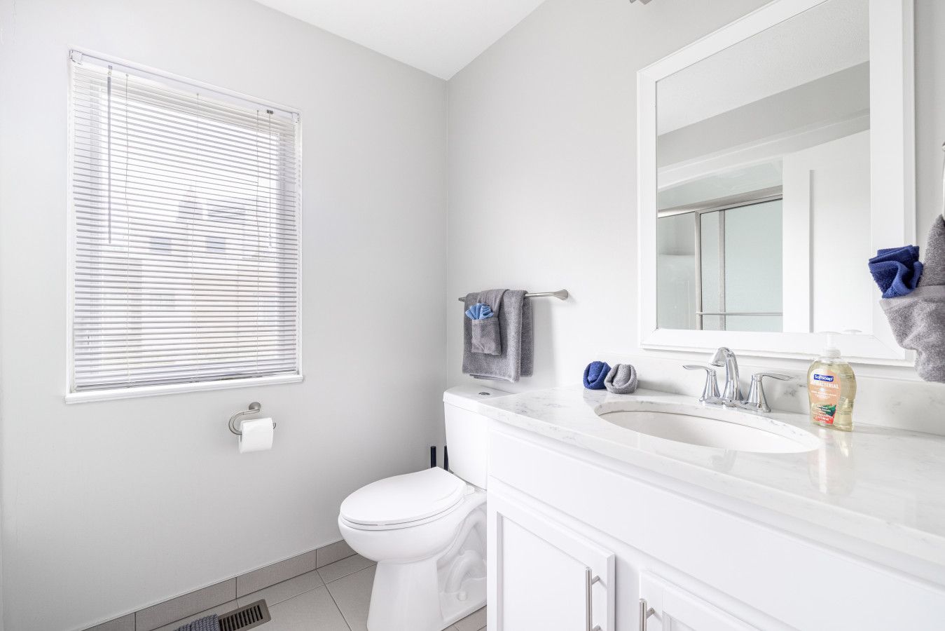 A modern bathroom with a toilet, sink, and mirror.