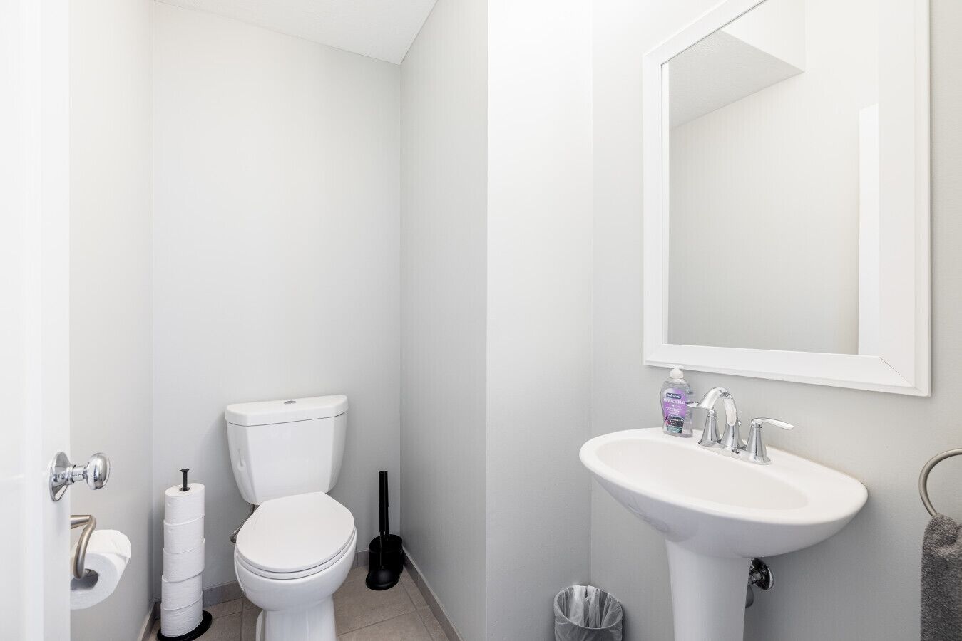 A modern bathroom with a toilet, sink, and mirror.