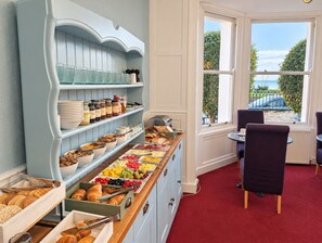 Un bufé de desayuno con diversas opciones de comida y vistas al exterior a través de una ventana.
