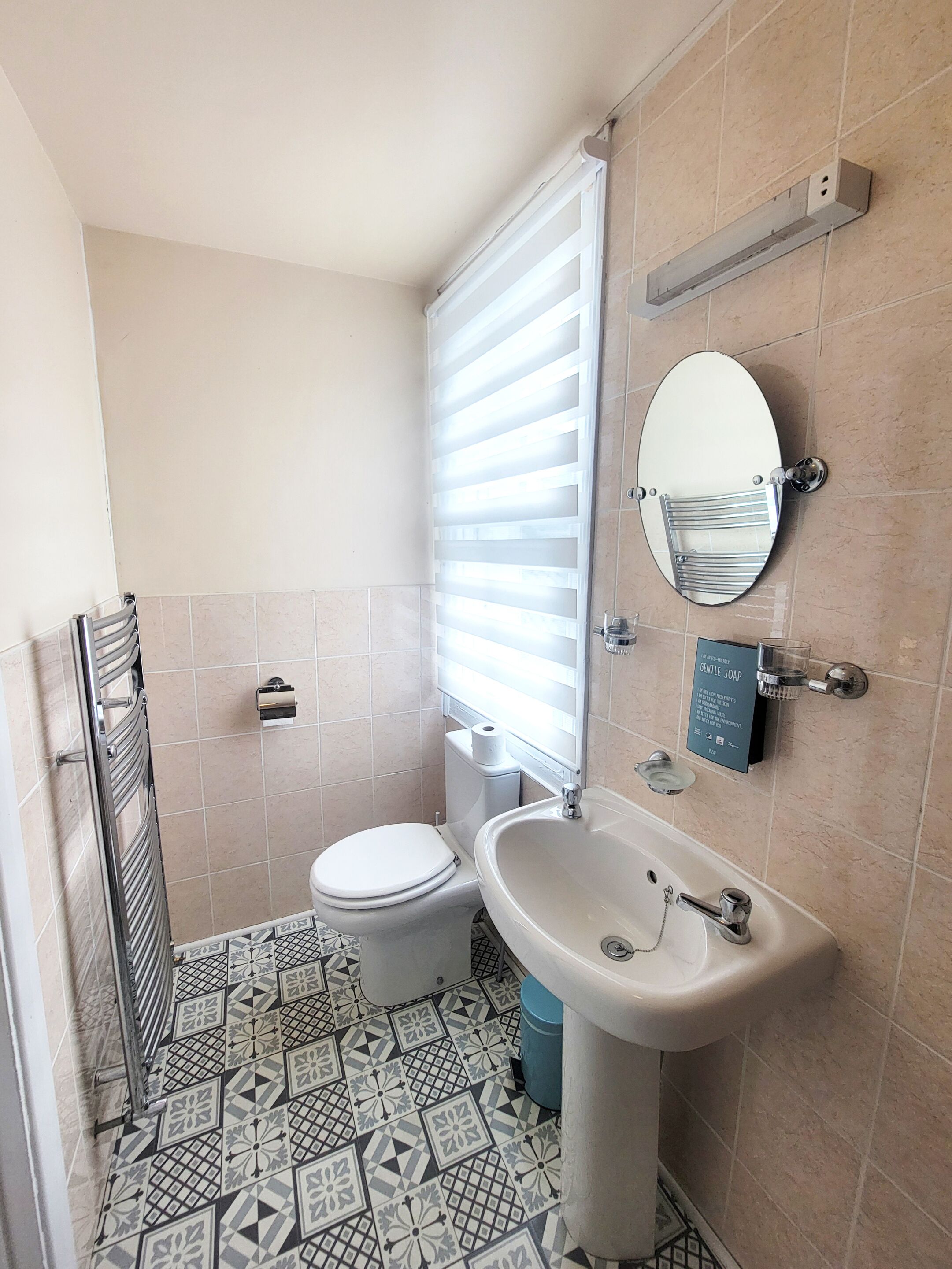 A bathroom with a toilet, sink, and mirror.