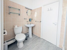 Kylpyhuone, jossa on wc, pesuallas ja peili.