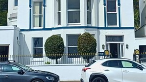 A two-story building with a white facade and blue trim. - Kings' House (Douglas)