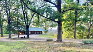 A lodge with a covered porch, surrounded by trees and a grassy area. - Buffalo Cabin Gorgeous Illinois River view (Tahlequah)
