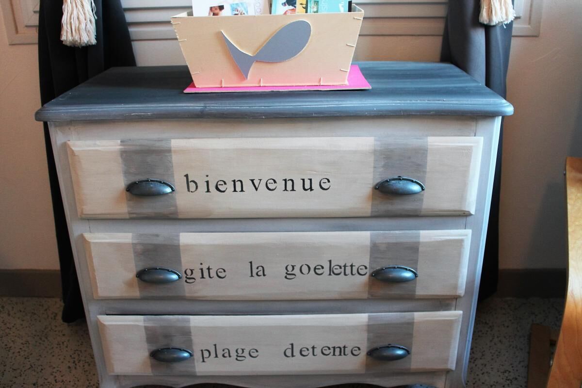 Een houten dressoir met laden, voorzien van Franse aanduidingen.