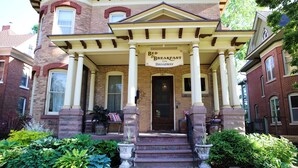 A Victorian-style building with a porch, columns, and a sign reading "Bed & Breakfast on Broadway." - B&B on Broadway (Decorah)