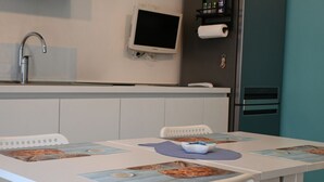 Een moderne keuken met een ingebouwde televisie, een spoelbak en een koelkast.
