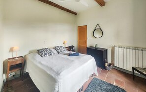 Makuuhuone, jossa on sänky, yöpöydät, lipasto, peili, patteri ja ikkuna.