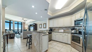 Una cocina amplia con armarios blancos, un horno de acero inoxidable y una isla grande.