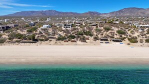 A coastal town with clear turquoise waters, sandy beaches, and a backdrop of mountains. - Funnest house in Baja! Game nights w/ smart darts, shuffleboard, & video games. Enjoy a new 8 person hot tub, lounge on multiple decks w/ firepits, fast Wifi ( 250 mb+)w/ Starlink backup. Use of 2 SUPs.  Daily housekeeping optional. (El Sargento)