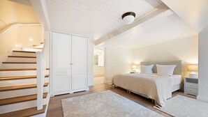 Un dormitorio con una cama grande, una mesita de noche y un armario.