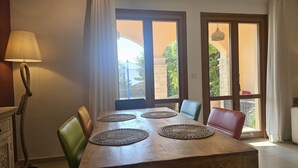 Un comedor con una mesa de madera, cuatro individuales tejidos y sillas.