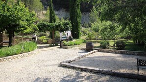 A gravel pathway leading to a seating area with a bench and a barbecue grill. - Country house at Le Barroux, Mont-Ventoux, air-conditioning, pets allowed (1) (LE BARROUX)
