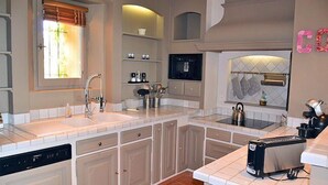 A modern kitchen with a dishwasher, double sink, and a toaster. - In Violès, Vaucluse, exceptional vacation home, air-conditioned, heated pool. (VIOLÈS)