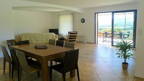 A dining area with a wooden table and chairs, a television, and a view of the outdoors through a large sliding glass door. - Air-conditioned villa in Montfort-sur-Argens, Var, private pool. (MONTFORT-SUR-ARGENS)