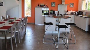 Une cuisine moderne avec des meubles blancs, un îlot central et des tabourets de bar.