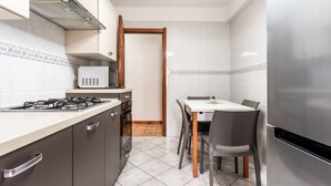 A modern kitchen with a gas stove, oven, microwave, and stainless steel refrigerator.
