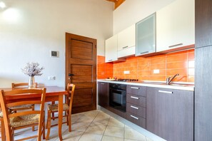 Uma cozinha com armários de madeira, bancada branca e azulejos laranja.