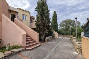 Il s’agit d’une propriété résidentielle avec un escalier menant à une porte, un mur en pierre et un lampadaire.