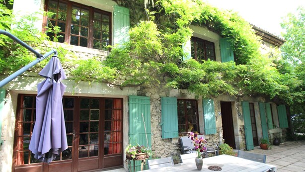 A rustic building with a stone facade, green shutters, and a wooden table with chairs. - Beautiful land house in Noves near Avignon, private pool, pets allowed (1). (NOVES)
