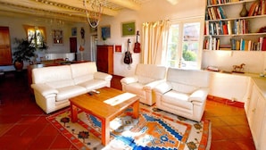 A spacious living room with white sofas, a wooden coffee table, and a patterned rug. - Vacation home in the Luberon in the heart of nature, private pool. (SAINT-MARTIN-DE-CASTILLON)