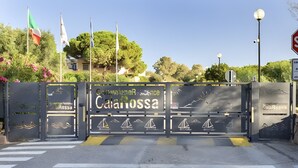 A gated entrance with a sign reading 'Comunione Residence Cala Rossa'.