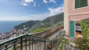 A coastal view with a staircase leading to a building with green shutters.