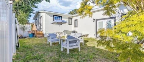 A backyard with a patio area, a small table, and two chairs.