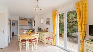 A kitchen with a dining table and chairs, a television, and a sliding glass door to an outdoor area. - Air-conditioned villa with pool in Vaison-la-Romaine, in the heart of Provence (Vaison-la-Romaine)