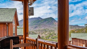 Eine Holzhütte mit Blick auf eine gebirgige Landschaft.