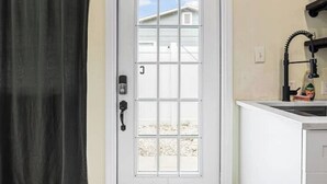 A white door with a window, a doorbell, and a keyhole.