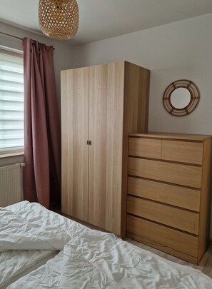 Ein Schlafzimmer mit einem Bett, einem Kleiderschrank und einem Spiegel an der Wand.