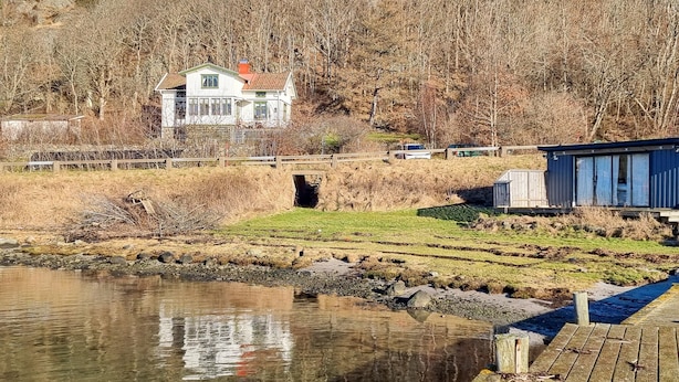 A house with a red roof, a wooden dock, and a river. - Nice home in Nösund with house sea view (Nösund)