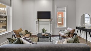 A modern living room with a fireplace, comfortable seating, and a flat-screen TV. - 3BR Historic St. Charles, MO-Walking distance to Main Street (Saint Charles)