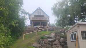 A house with a stone staircase leading to a wooden deck.