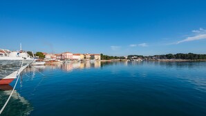 A marina with boats docked, buildings with red roofs, and a clear blue sky. - Apartman Porec Center Sea (Porec)