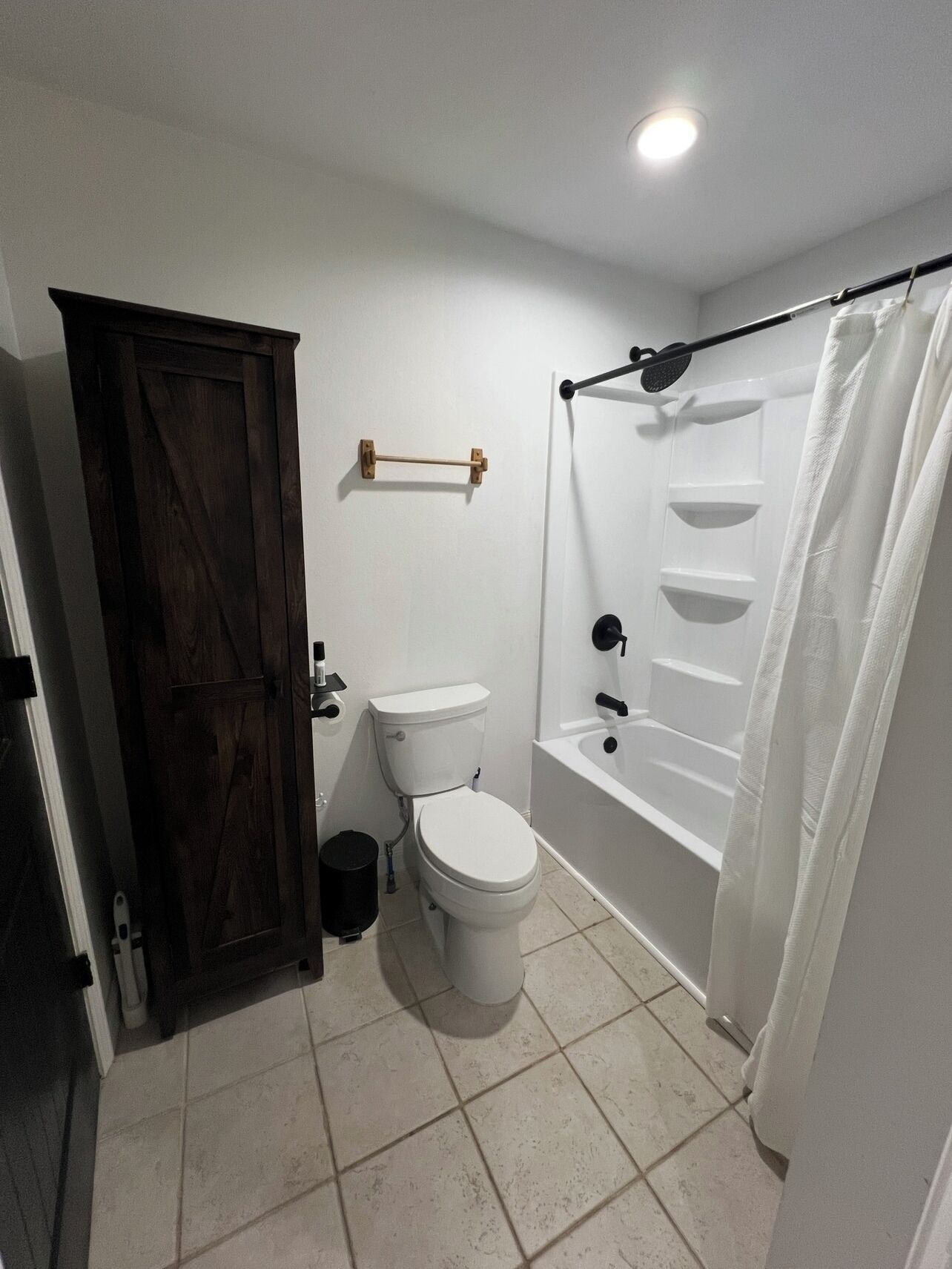 A bathroom with a toilet, bathtub, and shower curtain.