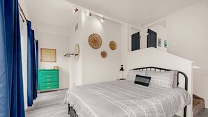 Ein Schlafzimmer mit Bett, Schminktisch und einer Treppe.