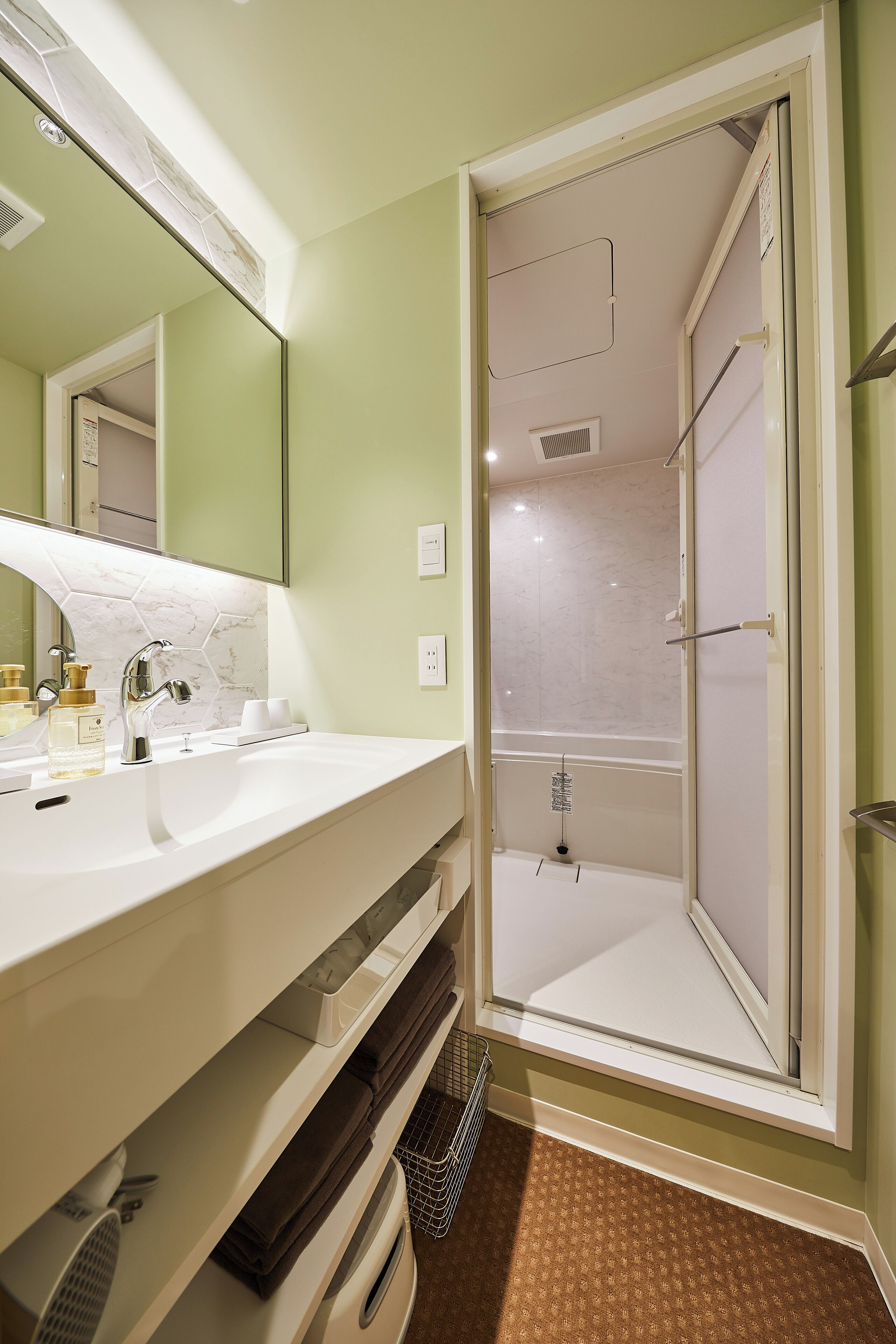 A bathroom with a white sink, a mirror, and a shower.