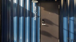 A modern building facade with a prominent door labeled "Mid-Century." - TORACO konohana (Osaka)