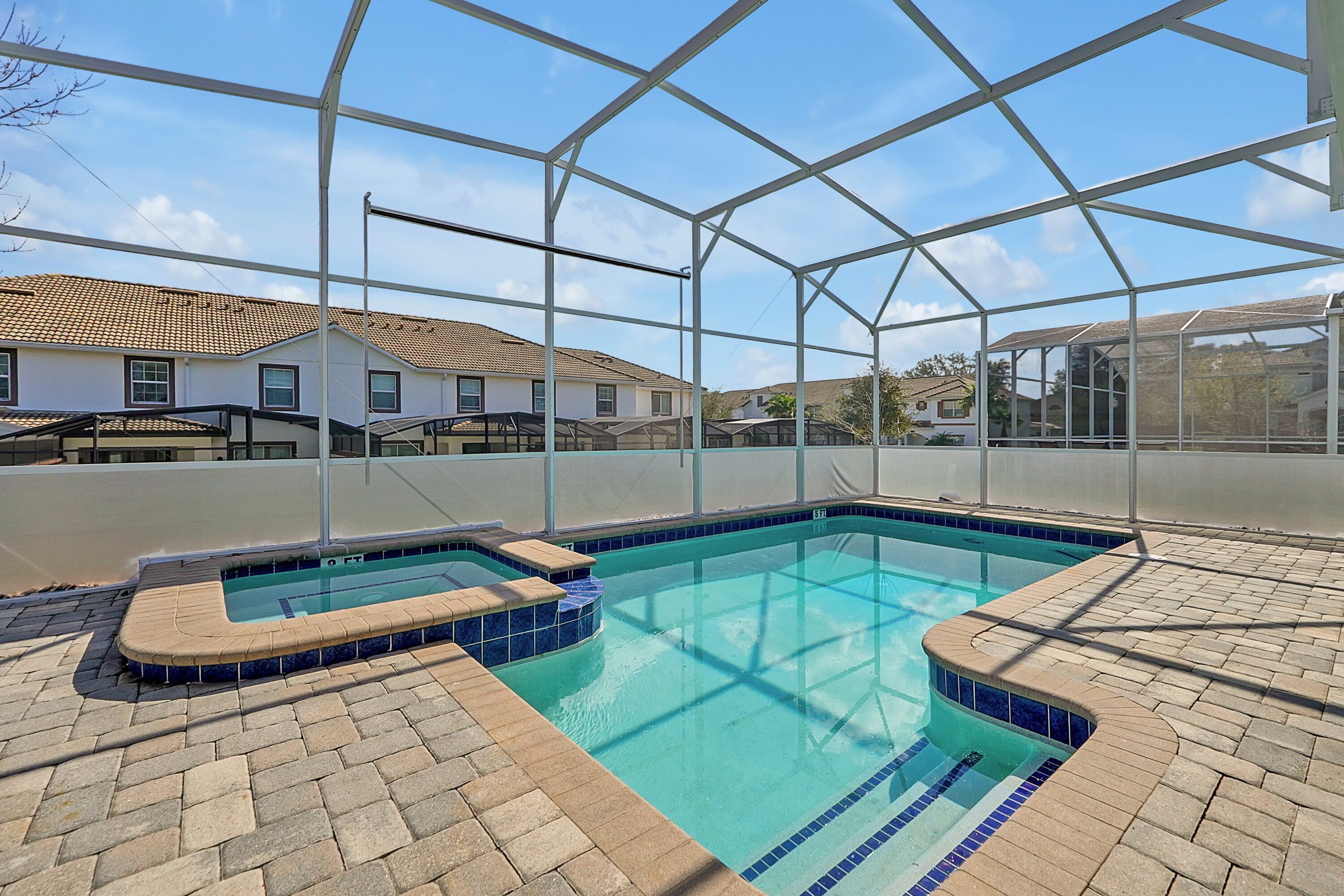 An indoor swimming pool with a clear view of the surrounding neighborhood.