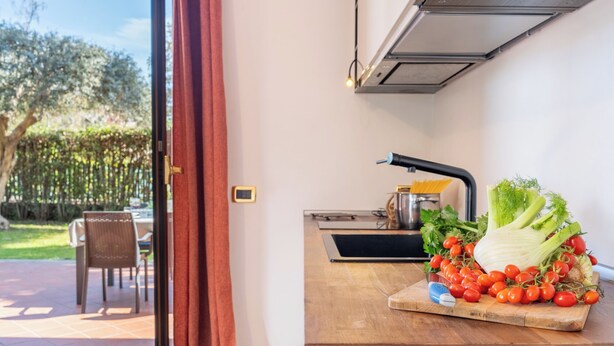 Een keuken met een houten aanrecht, een spoelbak en een raam met gordijnen.