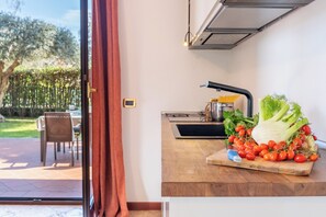 A kitchen with a wooden countertop, a sink, and a window with curtains. - Etna, mare e verde (double room in villa) (Mascali)