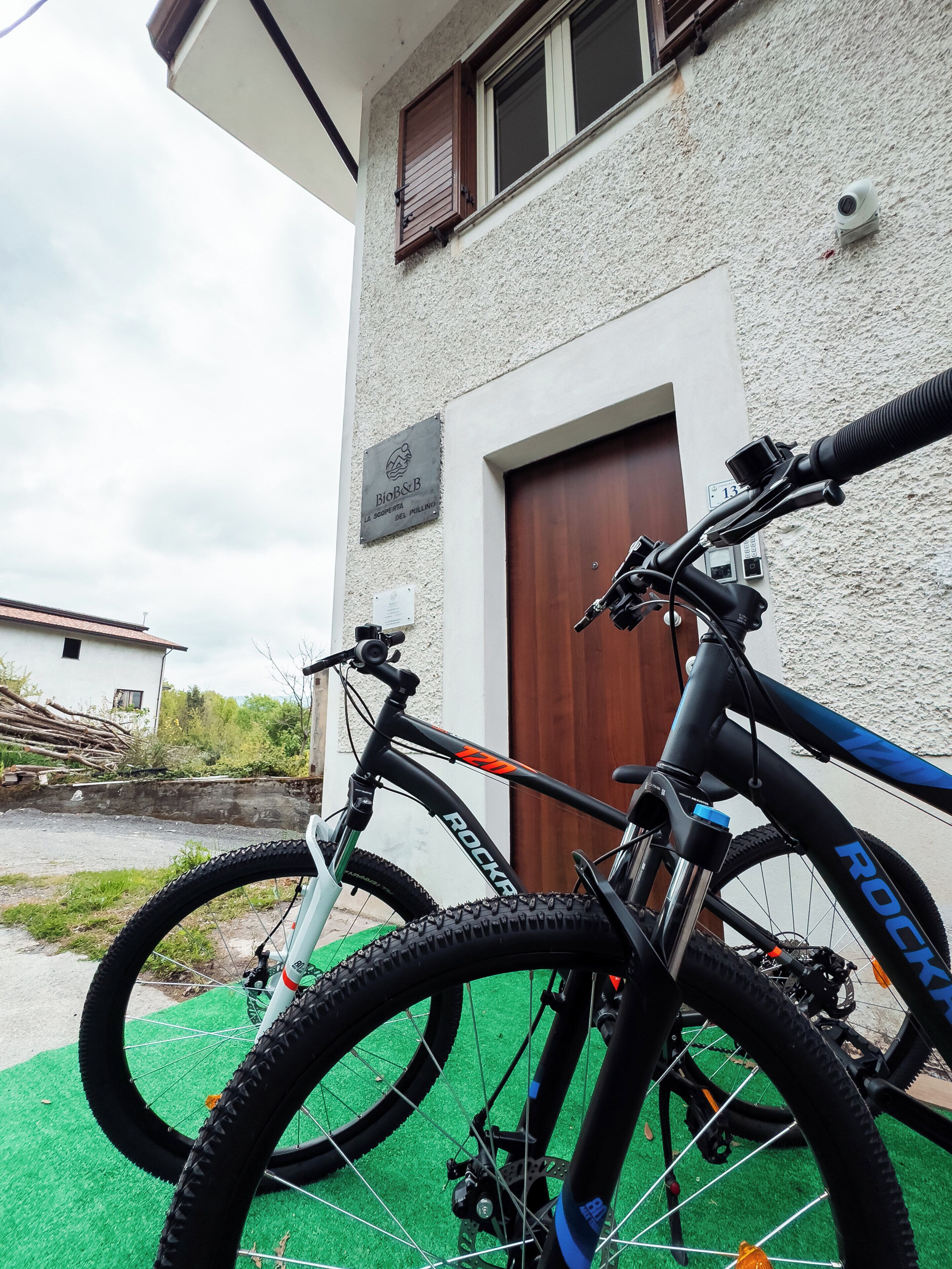 A mountain bike parked in front of a building with a sign reading "Bio&B".