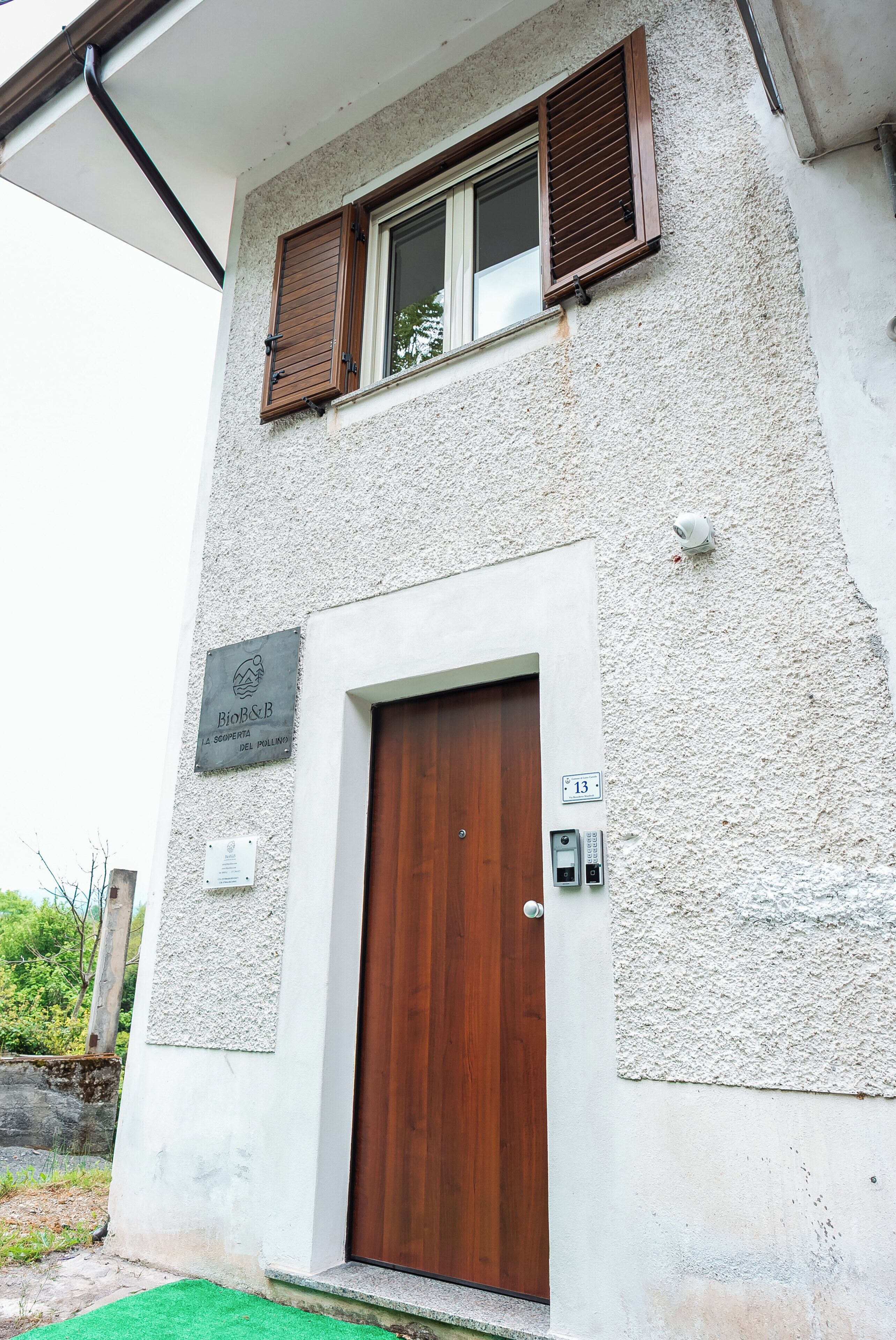 Un bâtiment à deux étages avec une porte en bois et une fenêtre dotée de volets bruns.