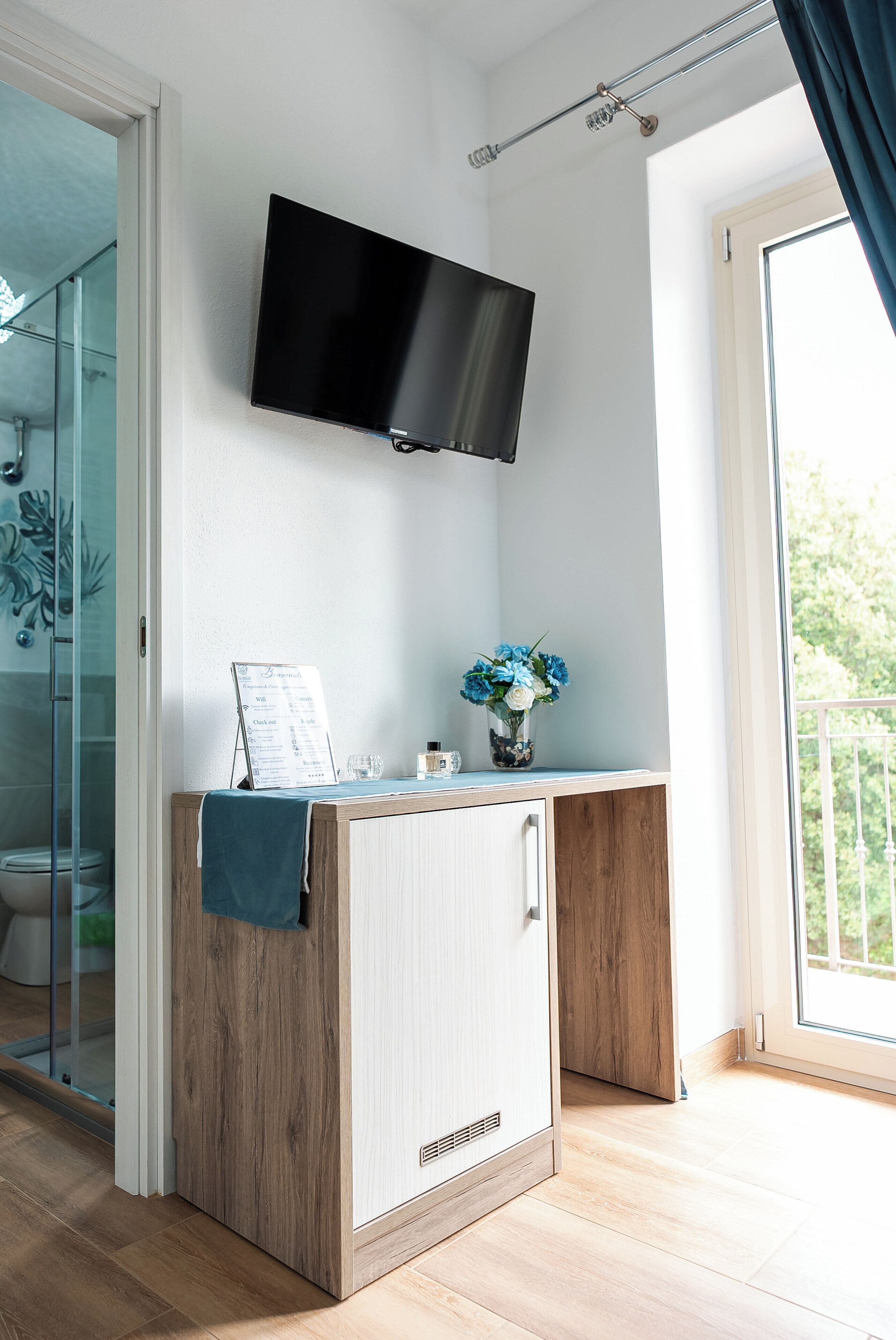 A bathroom with a shower, toilet, and a glass door leading to a balcony.