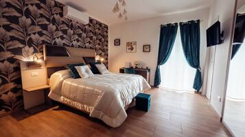 Un dormitorio con cama, mesitas de noche, espejo y ventana con cortinas.