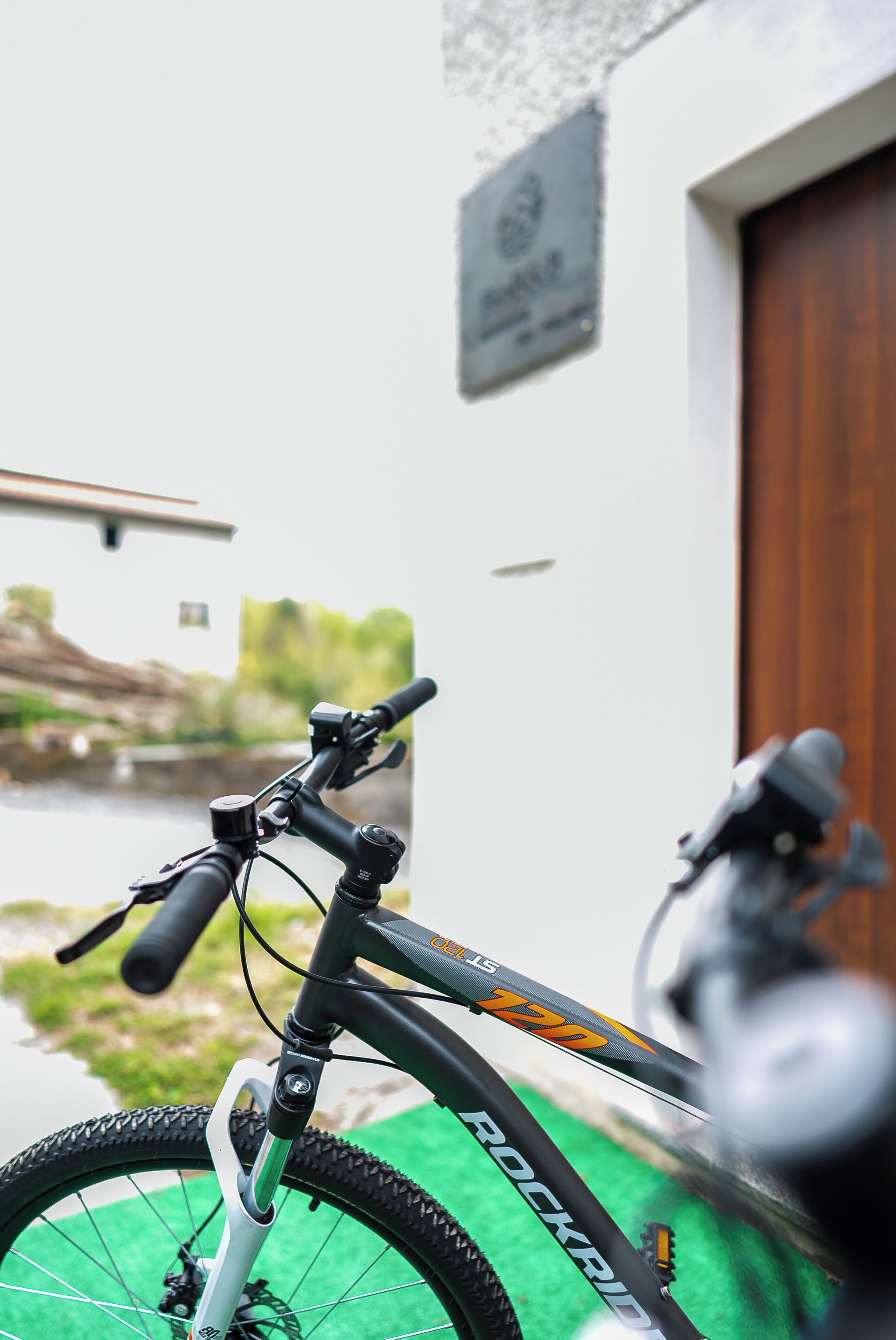 Uma bicicleta estacionada em frente a um edifício com uma placa que diz 'Rockridge'.